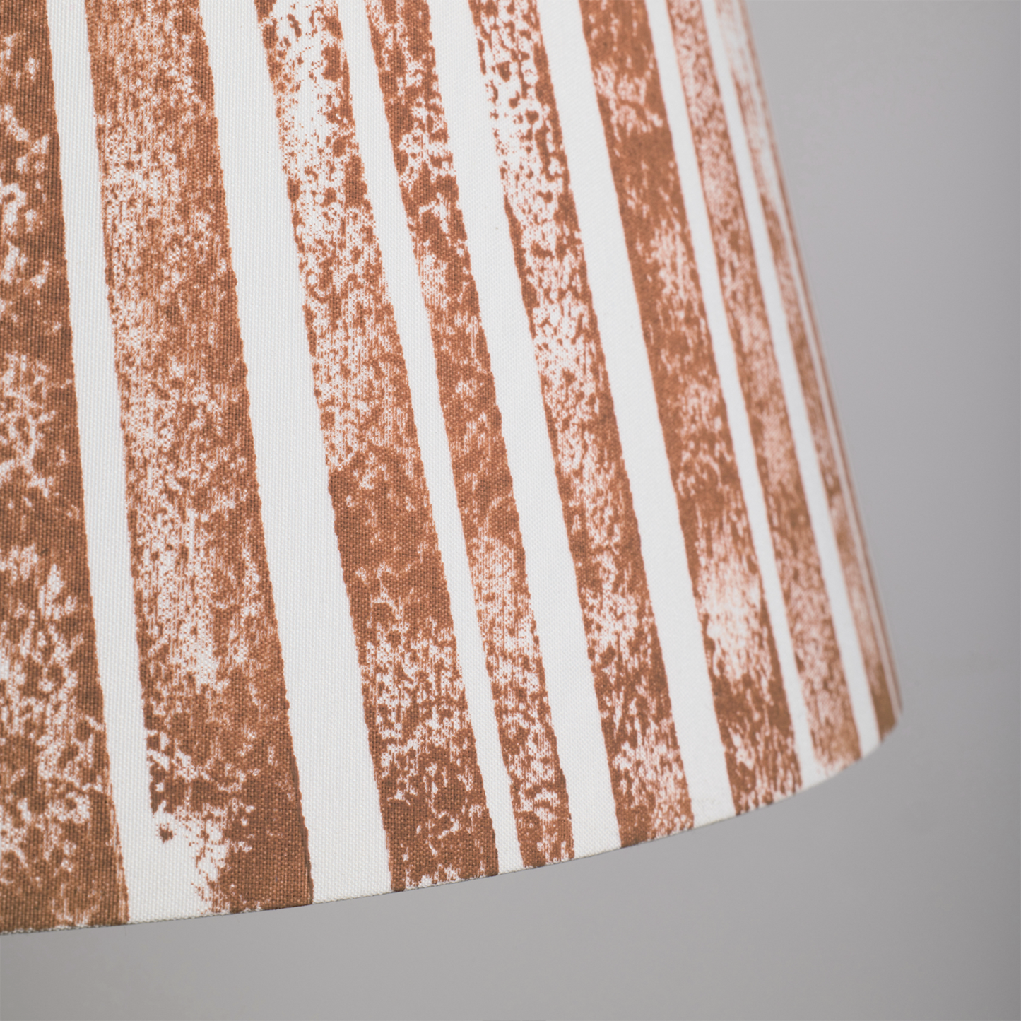 Close-up of the Devon Rock handmade lampshade showing its textured orange stripe pattern. A bold stripe lampshade with geometric detail, perfect as empire shades for table lamps, floor lamps and wall lights.