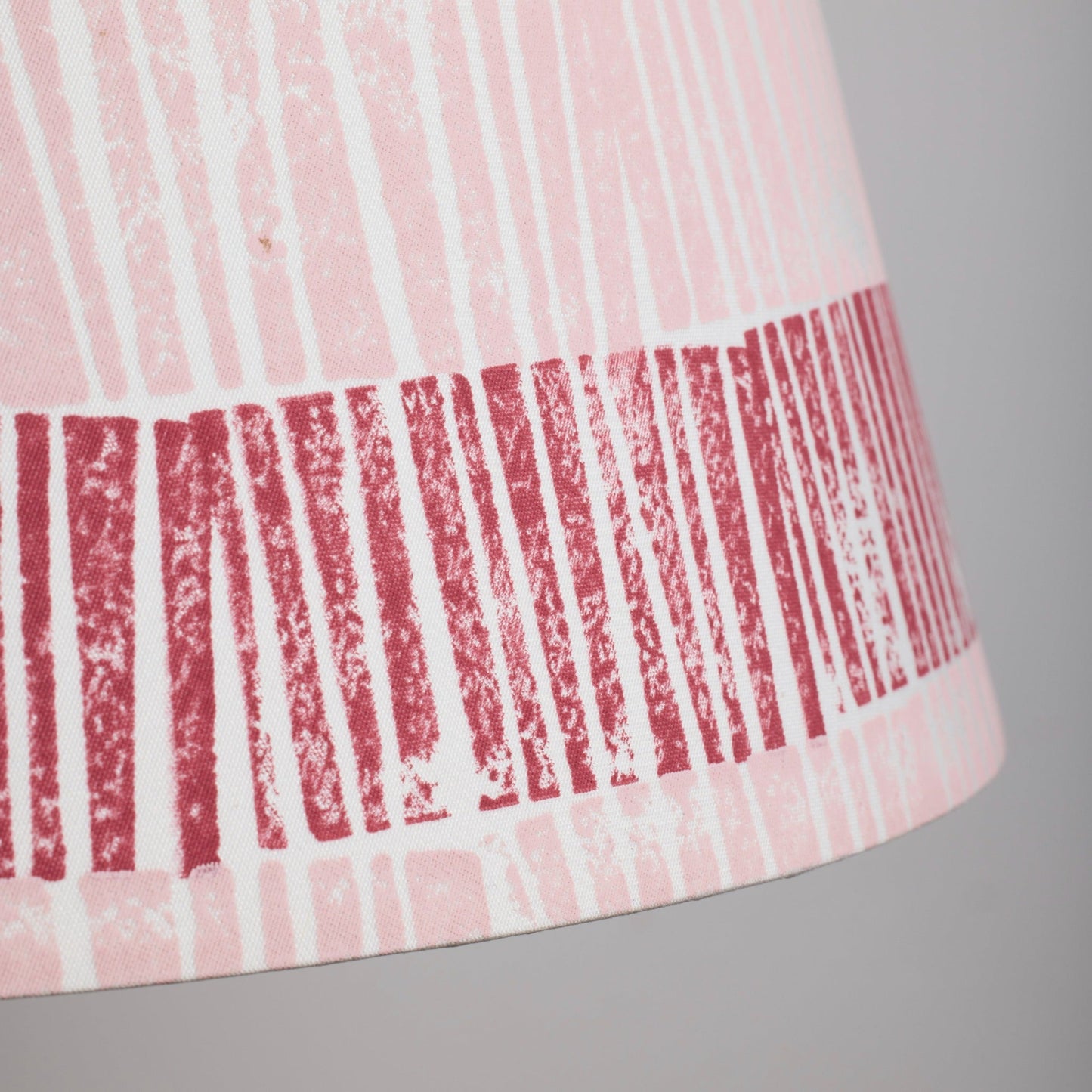 Close-up of pink and red lampshade showing bold ruched stripe texture, striped lampshades UK handmade for colourful and contemporary interiors.