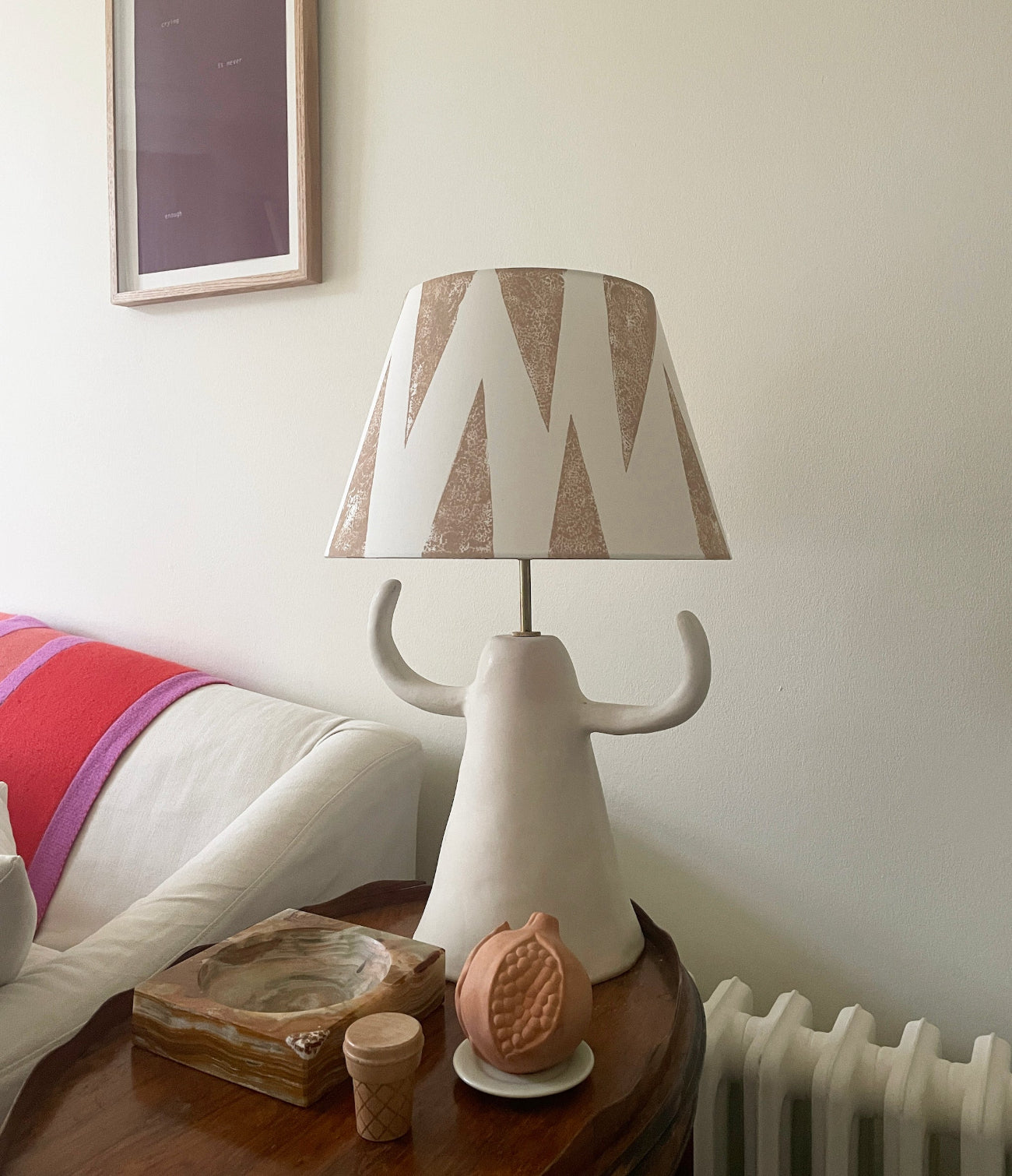 Cream empire lampshade with soft pink geometric triangle pattern styled on a sculptural ceramic lamp base. A bold lampshade with a neutral tone, ideal as a geometric lampshade for contemporary living rooms.