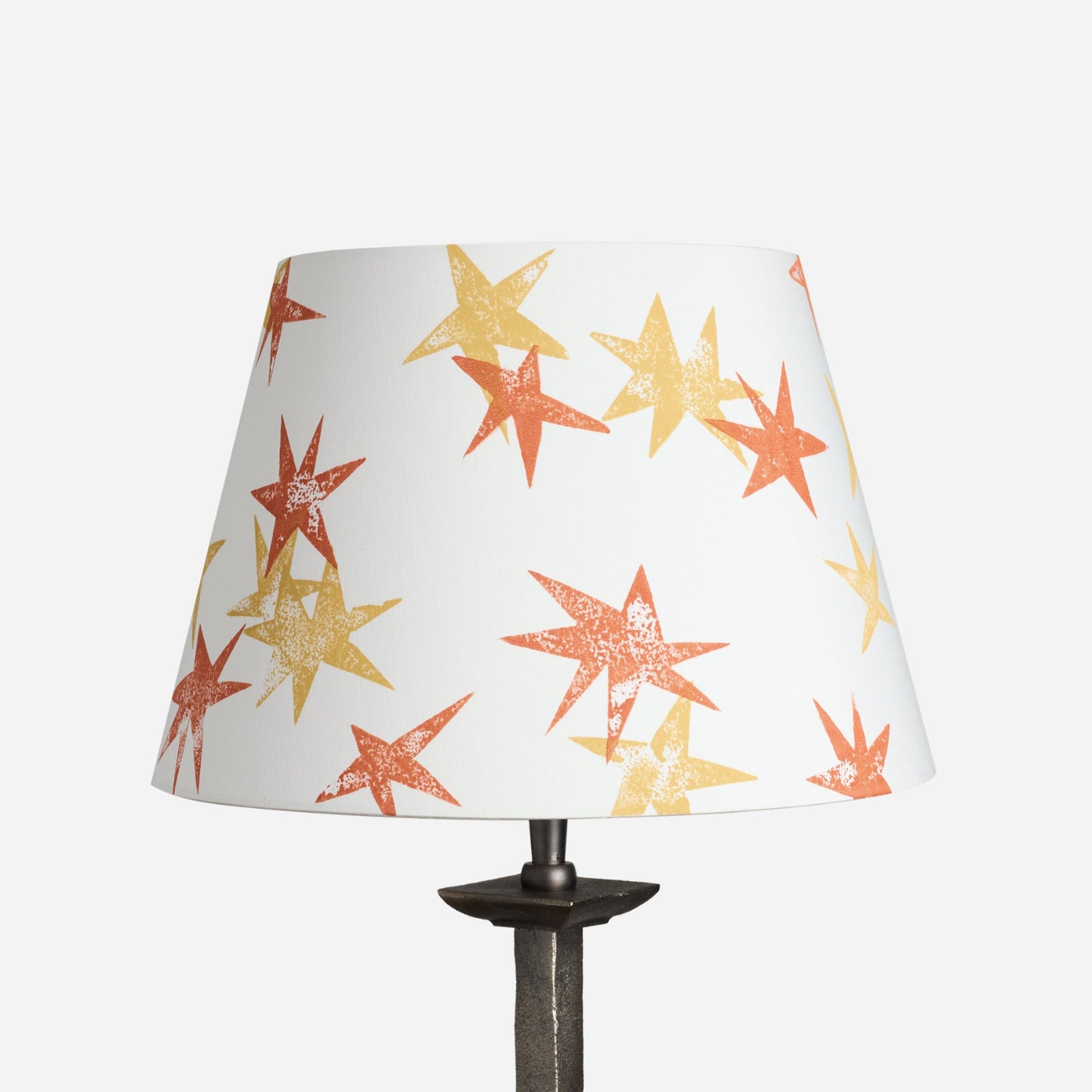 A stand-alone product shot of the Wonky Stars Lampshade in cream with scattered orange and yellow star prints. A bold lampshade and empire lampshade, perfect as empire shades for table lamps or kids lampshade styling.