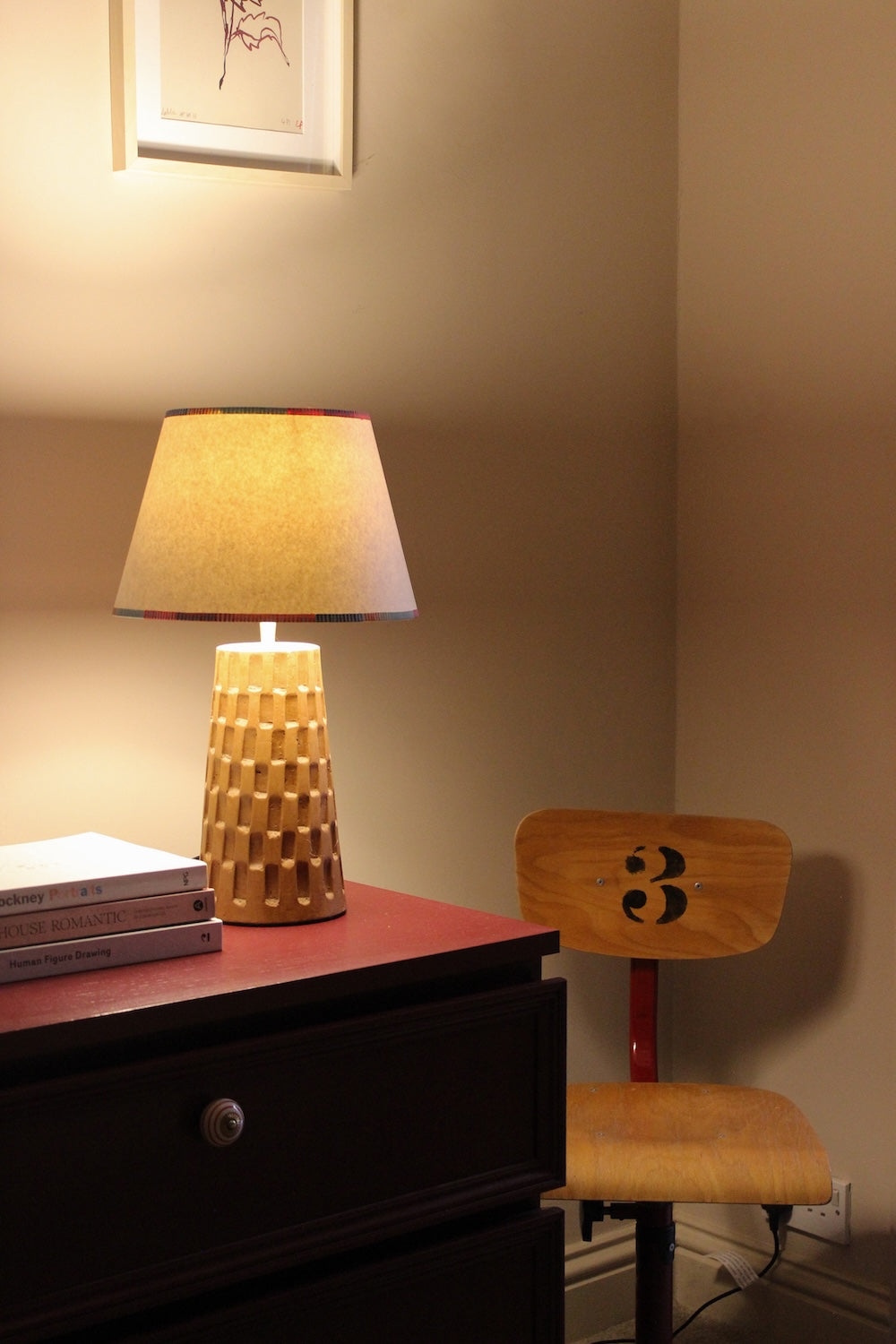 Colourful empire lampshade with striped trim illuminated in a cosy interior setting. A bold lampshade design that highlights striped lighting with warmth and charm.