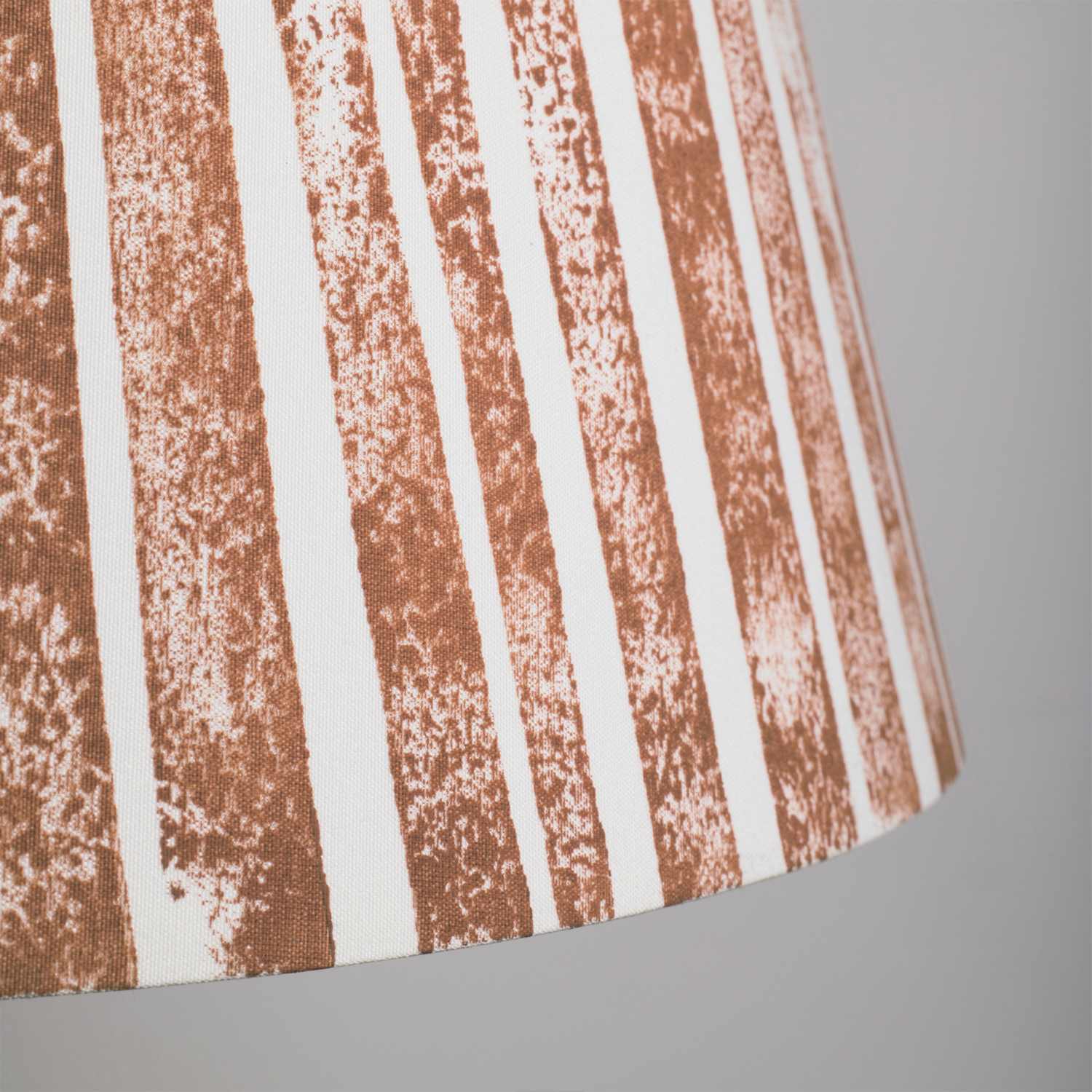 Close-up of the Devon Rock handmade lampshade showing its textured orange stripe pattern. A bold stripe lampshade with geometric detail, perfect as empire shades for table lamps, floor lamps and wall lights.