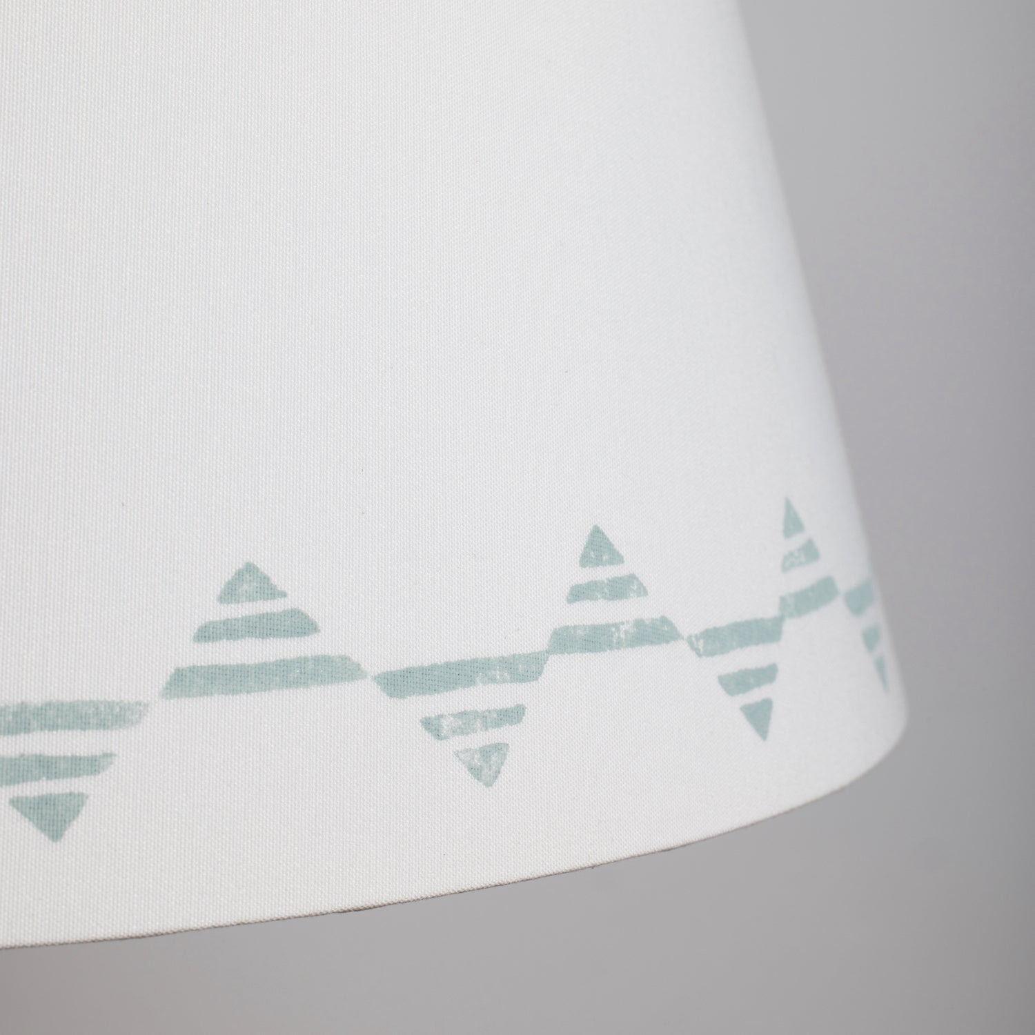 Close up of a cream lampshade with a blue triangle pattern – bold geometric empire lampshade in cream cotton, perfect for modern interiors.
