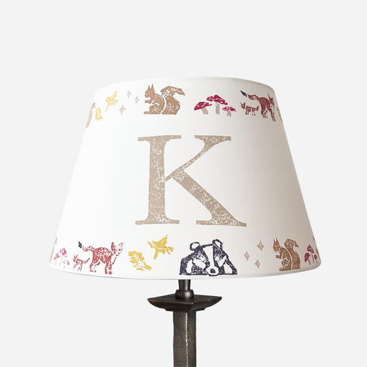 Personalised kids lampshade with woodland animals and the letter K, handmade empire lampshade in neutral tones. Empire light shade for kids bedroom design, featuring woodland animals, perfect as kids lighting or presents for new parents.