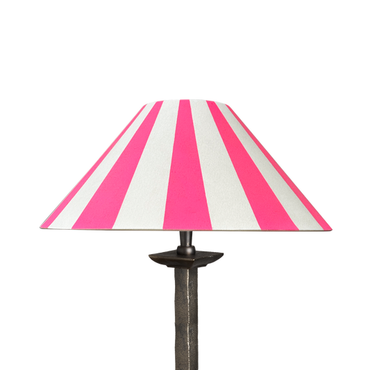 Neon pink and white striped lampshade on an iron lamp stand, set against a transparent background.