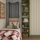 Boy’s bedroom with built-in bed, blue gingham canopy and personalised dinosaur lampshade, styled with dinosaur toys and colourful children’s decor.