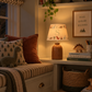 Cosy children’s reading nook at night with a personalised dinosaur lampshade featuring the initial S, styled with dinosaur books, toys and cushions.