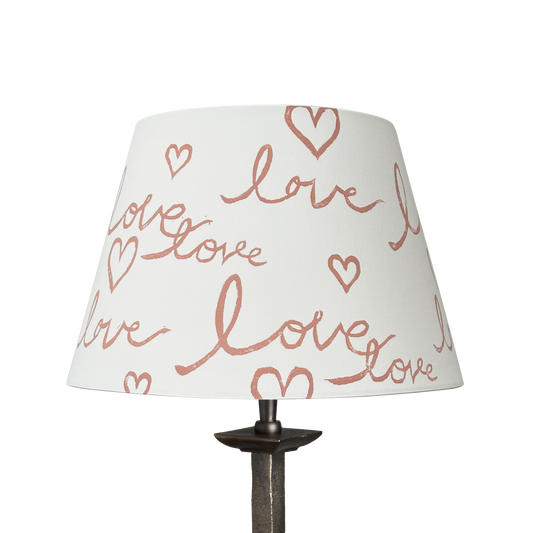 Handmade empire-shaped lampshade with a block-printed design featuring the handwritten word "love" and heart motifs. The lampshade is made from cream cotton and has a modern, romantic aesthetic.