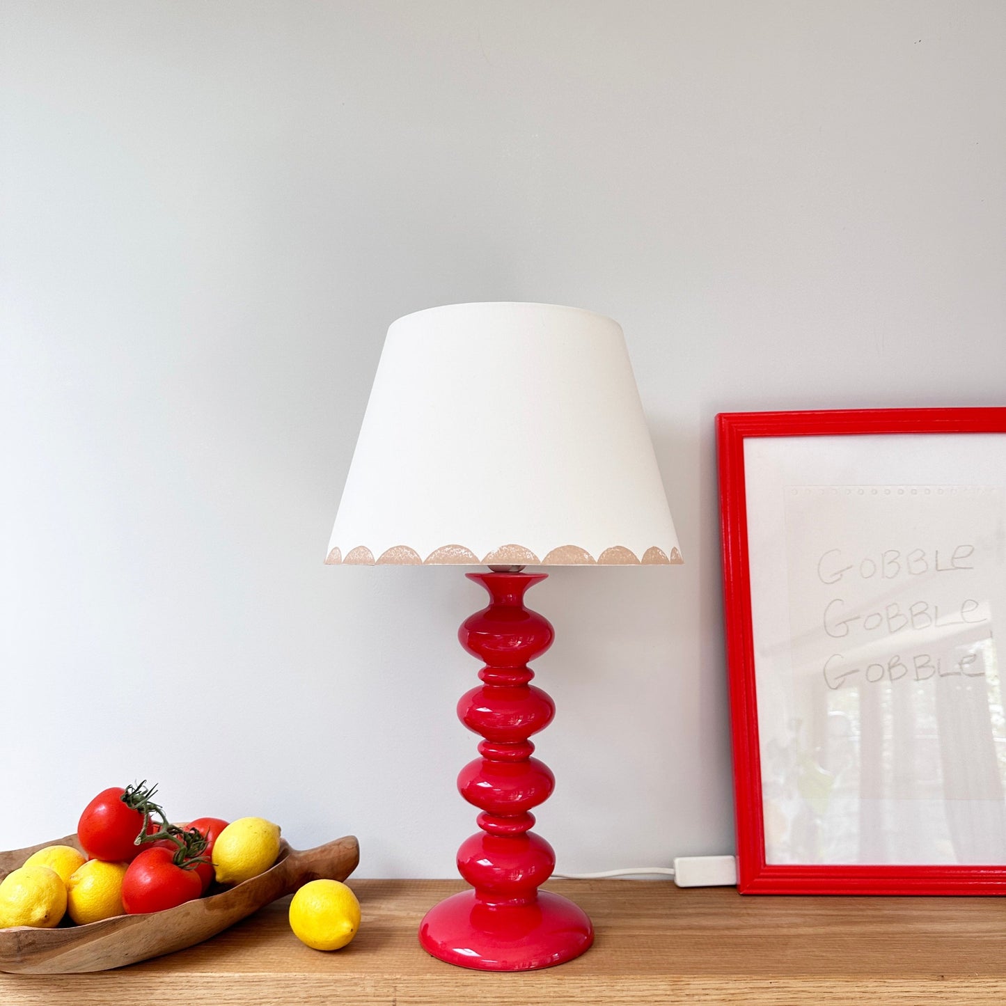 Pink scallop lampshade on red lamp