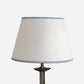 Empire lampshade with a subtle blue striped edge trim, designed as a bold lampshade with a minimalist twist. This stylish empire light shade combines classic white with fine blue stripe accents, making it a versatile striped lampshade for table lamps. A modern yet timeless choice for striped lampshades UK, ideal for creating understated striped lighting.