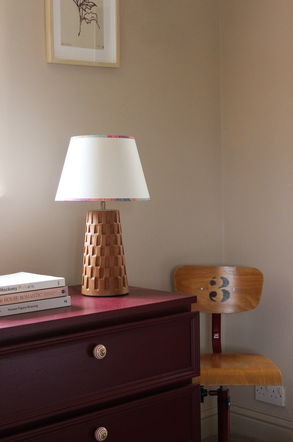 Pretty empire lampshade with colourful stripes at the top and bottom edges, styled with a carved wooden lamp base. A bold stripe lampshade perfect for adding character to bedside striped lighting setups.