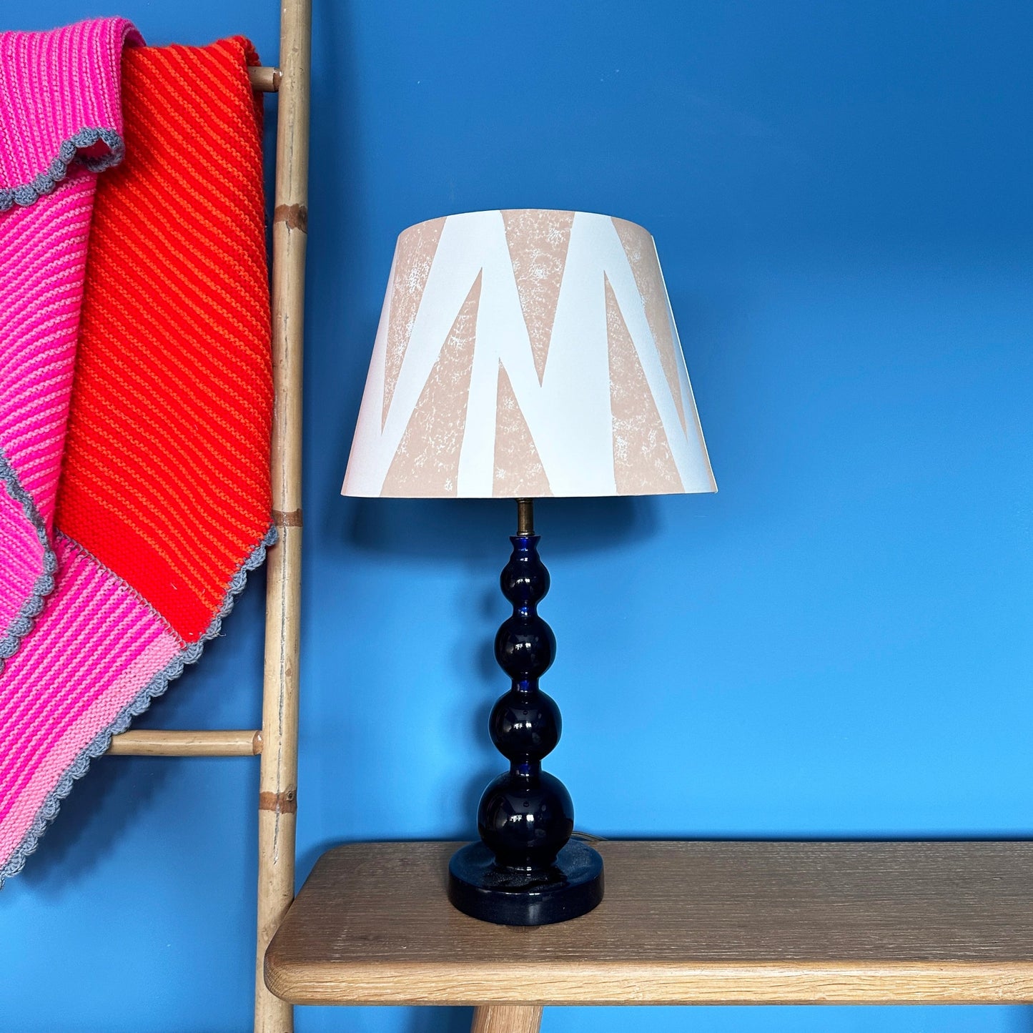 Pink lampshade with triangle pattern with blue background