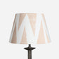 Studio product image of Tiger Tooth empire lampshade in cream with pale pink triangle pattern. A geometric lampshade with a bold yet subtle style, versatile as empire shades for table lamps or floor lamps.
