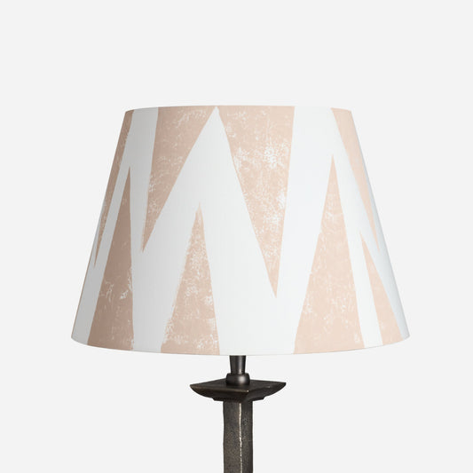 Studio product image of Tiger Tooth empire lampshade in cream with pale pink triangle pattern. A geometric lampshade with a bold yet subtle style, versatile as empire shades for table lamps or floor lamps.