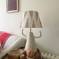 Cream empire lampshade with soft pink geometric triangle pattern styled on a sculptural ceramic lamp base. A bold lampshade with a neutral tone, ideal as a geometric lampshade for contemporary living rooms.