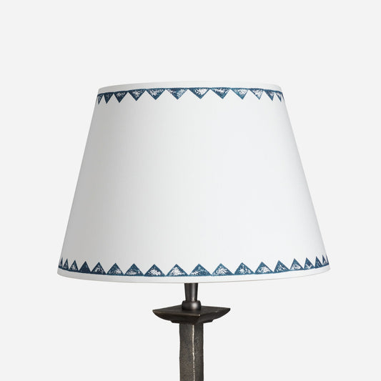 Product shot of cream empire lampshade with bold geometric lampshade design featuring a repeated navy blue triangle pattern along the edges, a stylish neutral lampshade.