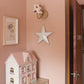 A wall-mounted empire light shade with bold red and pink stars, adding a playful accent to a girl's bedroom decor. The pink girls bedroom has a dolls house, books flower art. A star lampshade and colourful lampshade ideal for kids lampshade styling.