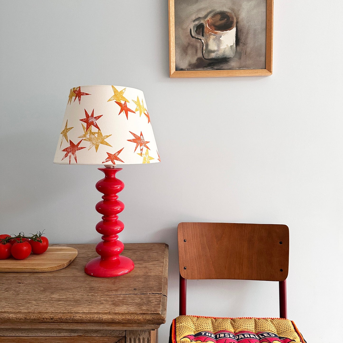Cream lampshade with orange and yellow stars on a red lamp