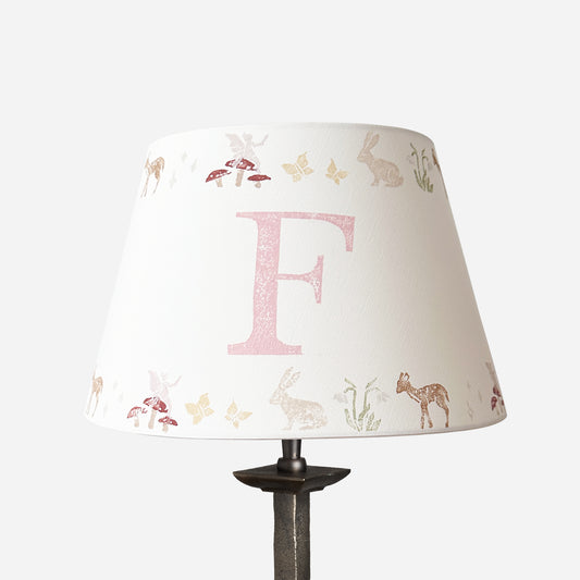 Studio Zef personalised woodland animals lampshade, a pink and cream empire lampshade featuring rabbits, deer, butterflies , fairies and mushrooms, designed as a pretty lampshade for kids bedroom décor.