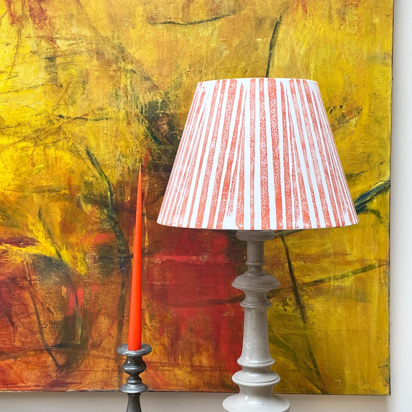 Orange lampshade with painting behind